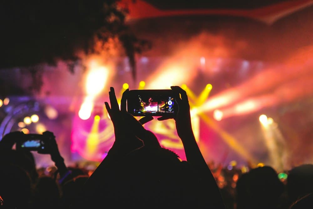 A guest holding up their phone at a concert